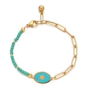 Detail of gold paperclip chain bracelet with turquoise beads and a star charm