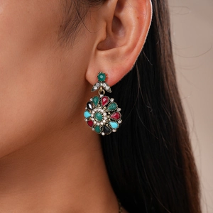 Close-up of vintage floral drop earrings with multicolored rhinestones on a female model