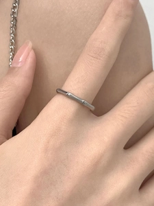 Macro detail of high-polish bamboo style stainless steel ring worn on finger