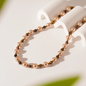 Detail of vintage necklace with faux tiger eye beads and pearls on a wave stand
