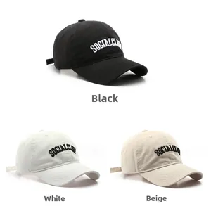 Dettaglio di tre cappellini ricamati in nero, bianco e beige con testo ricamato