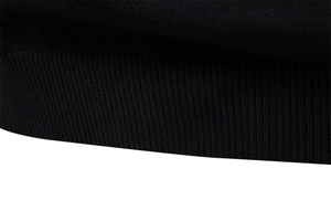 Gros plan sur la texture en maille côtelée noire des poignets et de l'ourlet du pull pour hommes