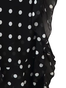 Detailed macro view of black chiffon dress fabric with white polka dots and ruffled edges