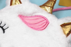 Vue détaillée du sac licorne en peluche avec corne dorée et broderie d'ailes roses