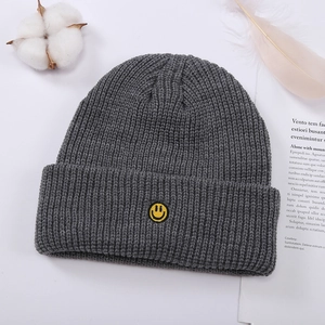 Gorro de invierno de punto gris oscuro con bordado de cara sonriente amarilla y tejido acanalado