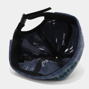 Détail du bonnet en denim vieilli montrant l'étiquette 100% coton et la sangle réglable
