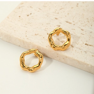 Detailed macro view of 18K gold stainless steel earrings with irregular lava texture