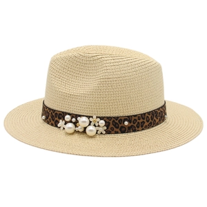 Detail of beige straw fedora featuring a leopard print band with pearls and floral accents