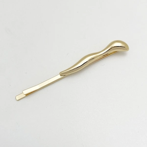 Close-up of a sleek gold-tone irregular alloy hair clip with a smooth metallic finish