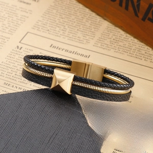 Détail d'un bracelet multicouche en cuir tressé noir pour homme avec chaîne serpent dorée