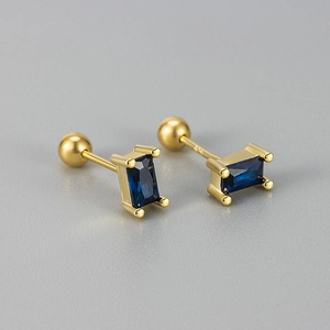 Macro shot of S925 silver screw stud earrings with gold finish and blue rectangle gems