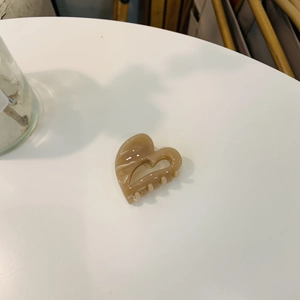 Detailed macro shot of an amber heart-shaped acetate hair claw with marble texture