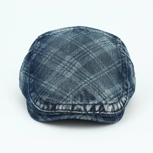 Detail of blue washed denim flat cap showing diamond pattern and woven texture