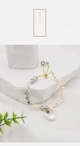 Detailed shot of baroque pearl and crystal beaded bracelet on a white stone background