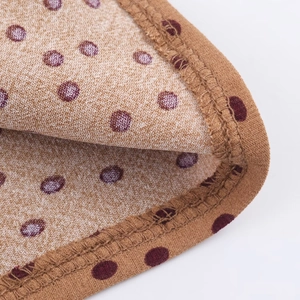 Detailed macro view of the light brown polka dot fabric and the fine stitching craftsmanship