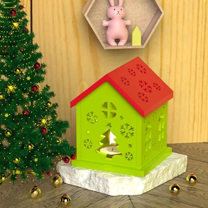 Detalle del portavelas casa de Navidad con recortes de copos y ambiente festivo