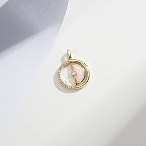 Macro shot of rotatable pink gold-plated pendant with crystals and centered gemstone
