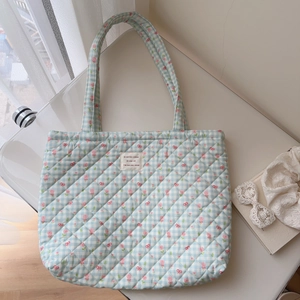 Close-up of floral quilted tote bag featuring tulip patterns and French fabric label