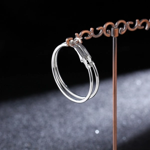 Macro view of polished silver hoop earrings with secure French clasp closure detail