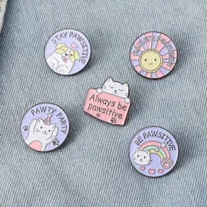 Set of 5 purple enamel cat and dog pins with positive quotes on denim fabric