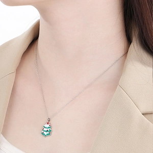 Gros plan d'un collier avec pendentif sapin de Noël aux détails en émail vert et blanc