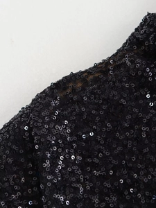 Macro detail of high-density black sequins on mesh fabric for an elegant evening dress