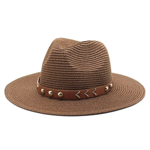 Close-up of brown straw cowboy hat with leather band featuring silver studs and V-accents