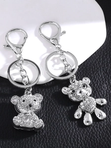 Macro shot of silver teddy bear charms with white rhinestones on black leather base