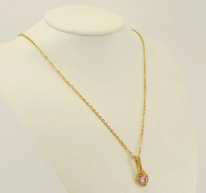 Close-up of gold chain necklace with round pink gemstone pendant on white neck model