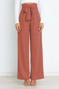 Détail du pantalon large taille haute terracotta avec nœud de ceinture élégant