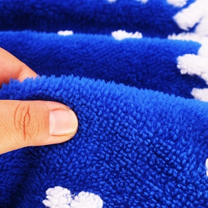 Close-up of soft thick blue plush Christmas tree skirt with white patterns and fuzzy texture