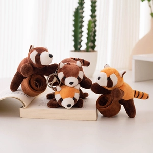 Cute red panda plush snap bracelets and keychains displayed on an open book