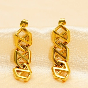 Macro shot of gold geometric link earrings on satin fabric, showing polished metal texture