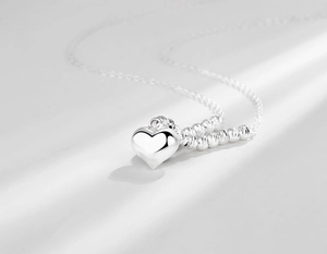 Macro detail of S925 sterling silver heart pendant with delicate beaded chain design