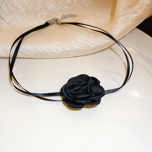 Gros plan d'un collier choker rose en satin noir avec de fins rubans doubles