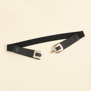 Detail of slim black elastic belt featuring a light gold square interlocking metal buckle