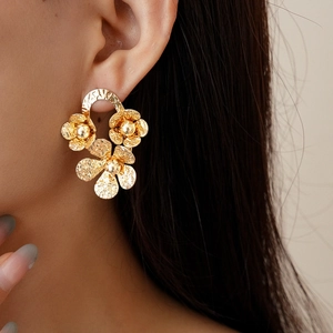 Boucles d'oreilles vintage fleurs dorées texturées avec perles métalliques sur modèle