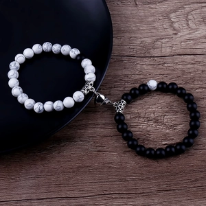 Close-up of black and white stone beaded couple bracelets with heart magnetic clasp