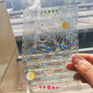 Rainbow prism window film showing a colorful cat with sun and moon designs in daylight