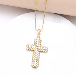 Collier croix plaqué or élégant serti de zircons brillants sur un support blanc épuré