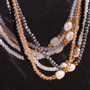 Detailed macro view of freshwater pearls and faceted crystals on a layered beaded necklace