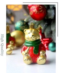 Close-up of a festive golden bear ornament with a red suit and green scarf for Christmas