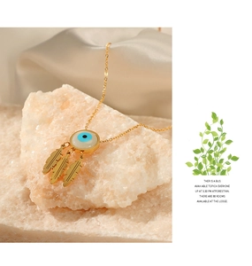 Detailed shot of golden evil eye necklace with feather pendants on crystal stone