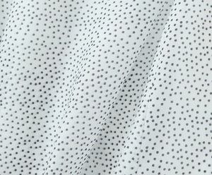 Detailed macro view of white chiffon fabric with black polka dots for a summer dress