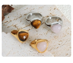 Detailed view of gold and silver tiger eye and rose quartz stones on stainless steel rings