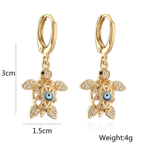 Detailed size view of gold-plated turtle earrings with blue evil eye and sparkling crystals