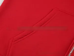 Detail of red zip-up hoodie featuring silver metal zipper and neat stitching on knit fabric