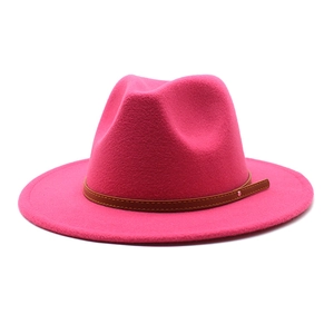Close-up of bright magenta wool fedora hat with brown leather band and metal stud
