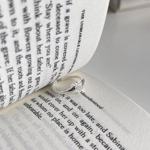 Macro shot of 925 sterling silver heart-shaped zircon ring inside an open book