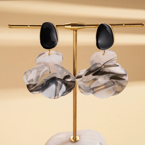 Vue détaillée des boucles d'oreilles fleurs avec pétales en résine marbrée et dorures